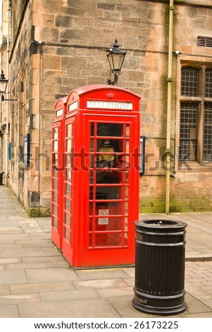 Detail of red telephone boxes in front of ancient building in Glasgow Scotland UK