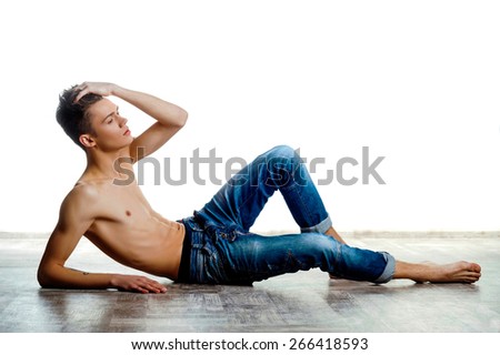 A young man with a beautiful physique. shirtless male model on white background