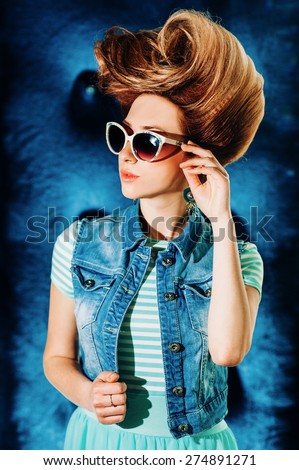 stylish girl model with retro hairstyle on a blue background. Pin-Up.