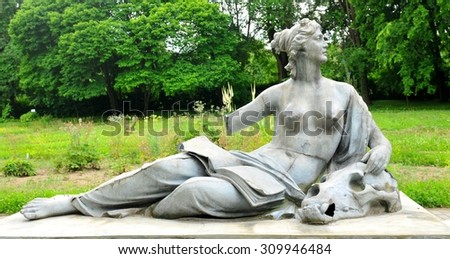 Bronze statue depicting nude woman with book and skull