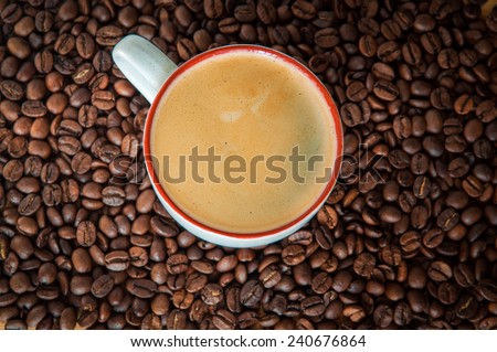 Coffee cup on a background of roasted coffee beans Roasted Coffee Beans. Photo coffee beans. Backgrounds.