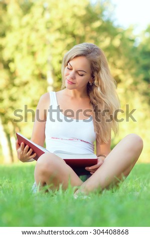 Girl with a book. Portrait of a beautiful girl with a book. The girl on the nature. Girl reading a book.