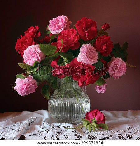 Red and pink roses in a vase. A still life with a bouquet of roses in a jug.