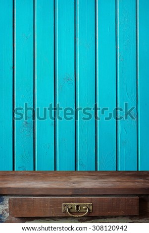 Empty wooden table against a wall from the boards painted by blue paint. A place for.