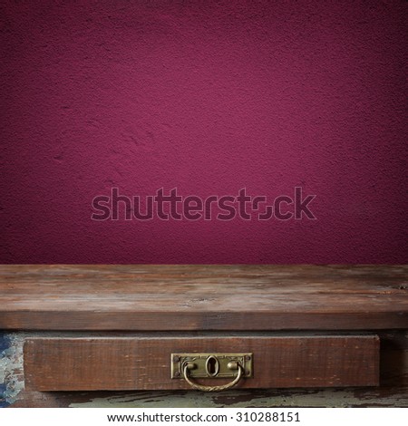 Empty wooden table against a violet wall. A template, a place for. Background, texture. Grunge texture.