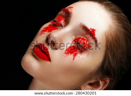 Beautiful woman with red pigment on her face.