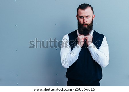 Stylish man businessman with beard , looking into the camera with her hands clasped .