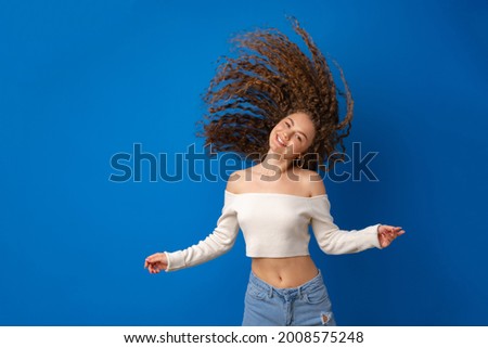 Portrait of young woman with long curly waving hair against blue background Foto stock © 
