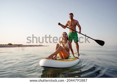 Similar – Image, Stock Photo Woman floating on paddleboard in lake