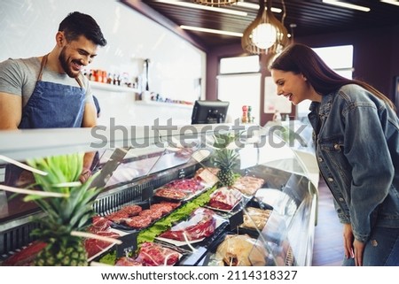 Butcher's shop seller helps to choose product to woman customer Stockfoto © 
