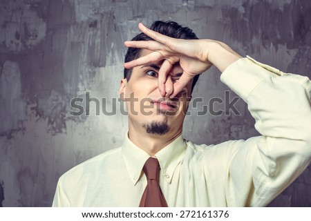 Young man covering nose against bad smell