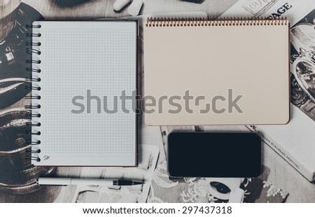 Note book and mobilephone on wooden office table.