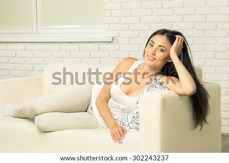 Young attractive woman at home sitting on couch