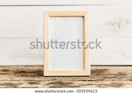 Blank wooden picture frame on wooden background