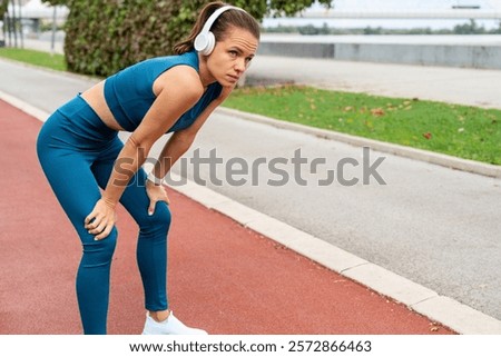 Image, Stock Photo Attractive female runner taking break after jogging outdoors