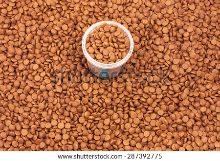 Dry brown pet food (dog or cat) with measure glass