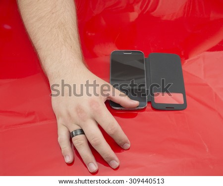 A man with his hand over his smartphone;