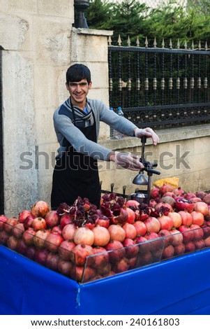 ISTANBUL, TURKEY - DECEMBER 24, 2014:Young man sells pomegranate juice on  Turkey ,December 24,2014.