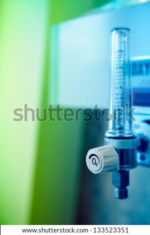 Wall-mounted close-up of oxygen flow meter oxygen in a hospital room. The flow meter is an inhalation apparatus to measure the amount of oxygen reaching the patient. Blue tone still life accent.