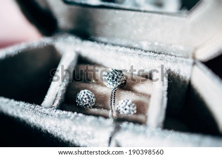 Necklace and pair of blue diamond crystal earrings in luxury storage box - beautiful jewelry - tilt-shift lens used to outline the object and to emphasize the attention on them
