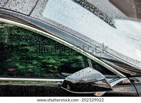 PARIS, FRANCE - JUNE 29, 2014: Tesla Motors model S sedan electric car lateral glass covered with rain drops as seen from above on June 29, 2014 in Paris.