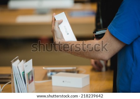 STRASBOURG, FRANCE - SEPTEMBER 19, 2014: A sales assistant scans new Apple iPhone 6 phones at the Apple Store on the first day of sales of the new smart phone on September 19, 2014