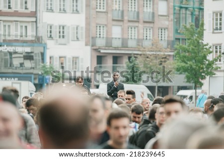 STRASBOURG, FRANCE - SEPTEMBER 19, 2014: Security guard looking above the crowd which stands in front of the Apple Store during the sales launch of the iPhone 6 and iPhone 6 Plus in Europe