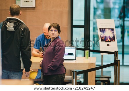 STRASBOURG, FRANCE - SEPTEMBER 19, 2014: Woman waiting the queue for the purchase of an iPhone 6 during the sales launch of the iPhone 6 and iPhone 6 Plus at the company\'s Place Kleber store in France