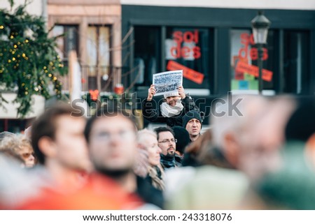STRASBOURG, FRANCE - 11 JAN, 2015:  People hold placards reading \'Charlie is alive!\' during a unity rally (Marche Republicaine) where some 50000 took part in tribute three-day killing spree in Paris