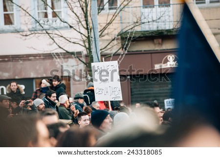 STRASBOURG, FRANCE - 11 JAN, 2015: People hold placards reading \'Subscribe or daesh is coming\' during a unity rally (Marche Republicaine) where some 50000 took part in tribute three-day killing spree