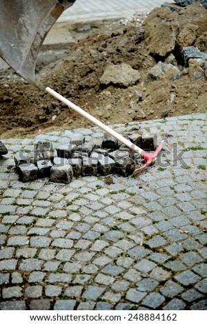 Pick axe near granite blocks on a fresh excavated street
