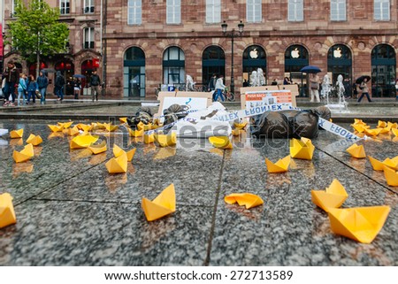STRASBOURG, FRANCE - APR 26 2015: Yellow paper boats and dead corpses at protest against immigration policy and border management which asks for commitment in the wake of migrants boat disasters
