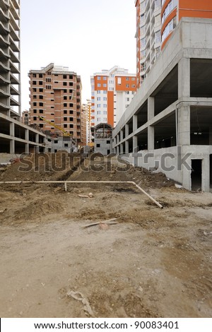 Construction site with great perspective showing finished houses in the background. Useful file for your construction site, brochure or advertising about your new apartment complex.