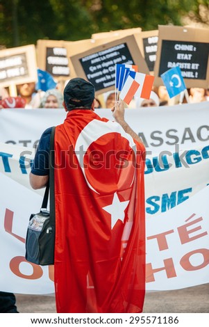 STRASBOURG, FRANCE - JULY 11, 2015: Man wearing Turkey flag and holding French flags - Uyghur human rights activists participate in a demonstration against Chinese government\'s policy in Uyghur