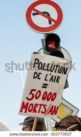 STRASBOURG, FRANCE - AUG 6, 2015: People wearing air masks protesting against air pollution in Strasbourg, Alsace, France -  placard near street sign Air pollution kills 50000 people per year
