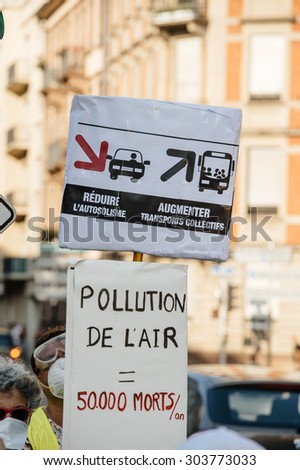 STRASBOURG, FRANCE - AUG 6, 2015: People wearing air masks protesting against air pollution in Strasbourg, Alsace, France - placard: less cars more public transport