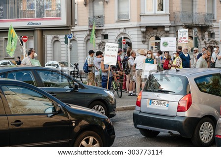 STRASBOURG, FRANCE - AUG 6, 2015: People wearing air masks protesting against air pollution in Strasbourg, Alsace, France - crowd protesting at busy crossroad