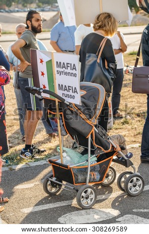 STRASBOURG, FRANCE - AUG 20, 2015: People protesting in front of European Parliament denouncing the Syrian airstrikes on Douma wheremore 80 were killed - syrian mafia equals russian mafia palcard