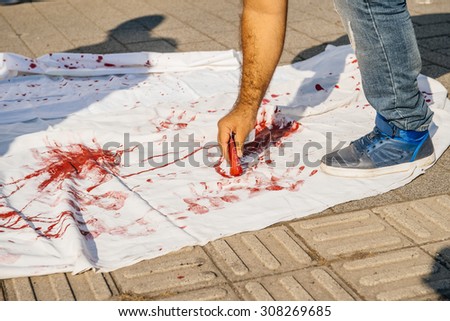 STRASBOURG, FRANCE - AUG 20, 2015: People protesting in front of European Parliament denouncing the Syrian airstrikes on Douma wheremore 80 were killed - blood immitation on white tissue