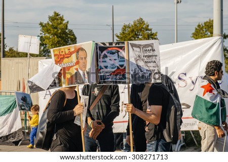 STRASBOURG, FRANCE - AUG 20, 2015: People protesting in front of European Parliament denouncing the Syrian airstrikes on Douma wheremore 80 were kille - placard syrian mafia equal russian mafia