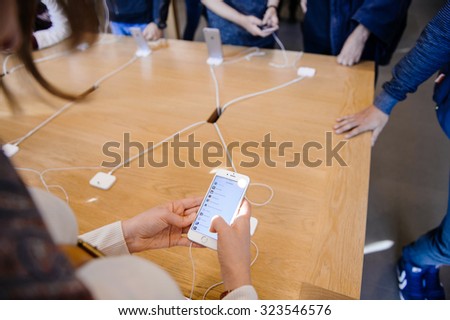 PARIS, FRANCE - OCT 3, 2015: Customer checks the new iPhone 6s displayed at the Apple Store Opera with the App Store Top Apps