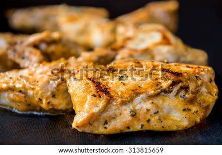 close up of grilled seasoning delicious looking chicken breast on black silicone mat