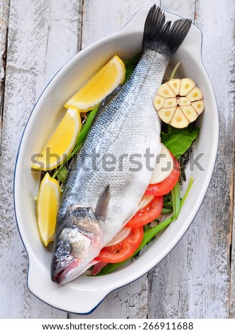 raw fish with herbs, vegetables and garlic, selective focus