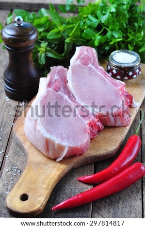 raw pork chop on the bone with parsley, mint, pepper and sea salt