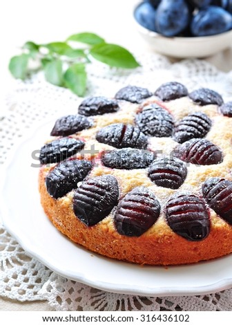 Organic plum cake with powdered sugar on a white background