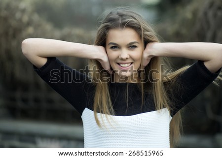 Portrait of a charming young woman with long hair looking forward and smiling, horizontal photo