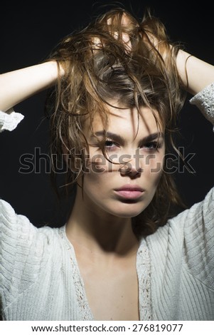 Elegant languid young woman with wet curly hair up looking forward, vertical picture