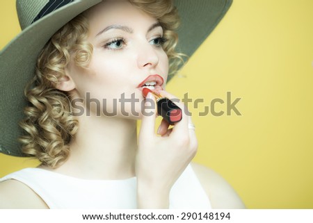 Beautiful woman in a white dress rouges with lipstick