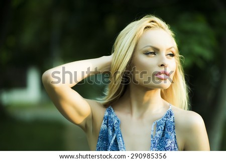 Portrait of thoughtful pretty blond woman outdoor in summer daylight on natural background, horizontal picture