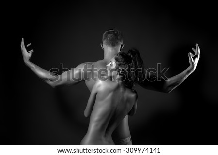Pair of slim stripped woman embracing young man with sexual strong muscular attractive body with raised arms in sides and standing in studio black and white, horizontal picture